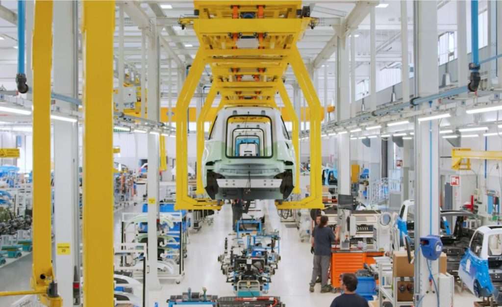 AMFI e Komma/ nuovo veicolo elettrico catena montaggio con gente a lavoro